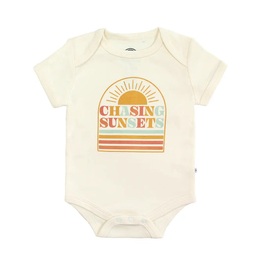Baby onesie with 'Chasing Sunsets' design on a white background