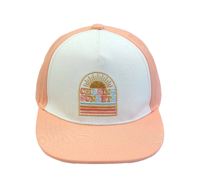Flat Lay image of our Chasing Sunsets Snapback hat for babies and kids. The hat has a peach rim and back while the "Chasing Sunsets" emblem is placed on the white canvas in the front. 