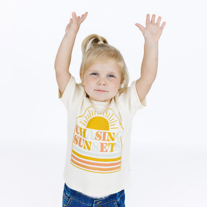 Child wearing a white t-shirt with a colorful design on a white background