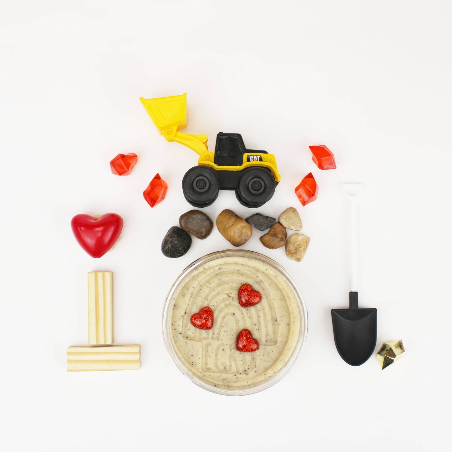 Children's play dough with construction-themed tools and toys on a white background