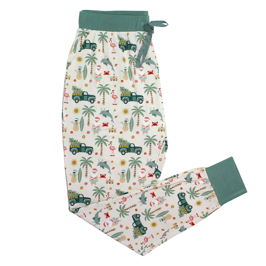 the "coastal christmas" women's jogger pajama pants. the "coastal Christmas" print is a mix of sandman, beach Santas, decorated palm trees, flamingos with Santa hats, dolphins with reindeer antlers, craps, suns, shells, and starfish scattered around a white background. 