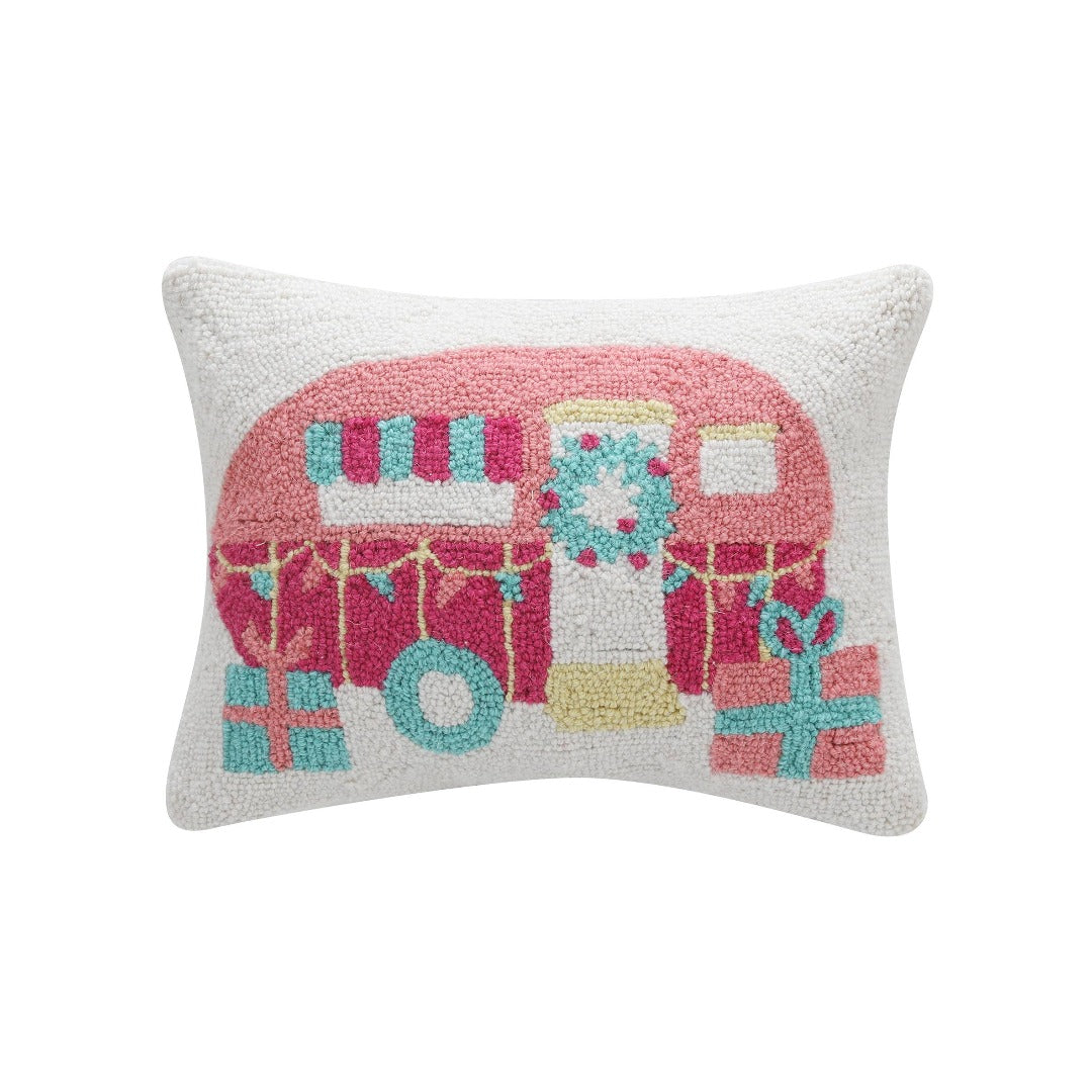 white pillow with a pink, blue, and yellow christmas decorated camper.