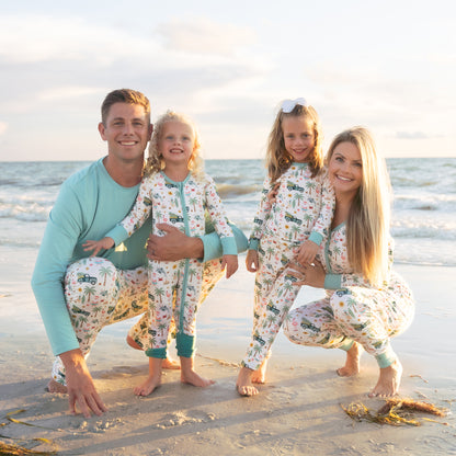 Family of four in matching pajamas on a beach