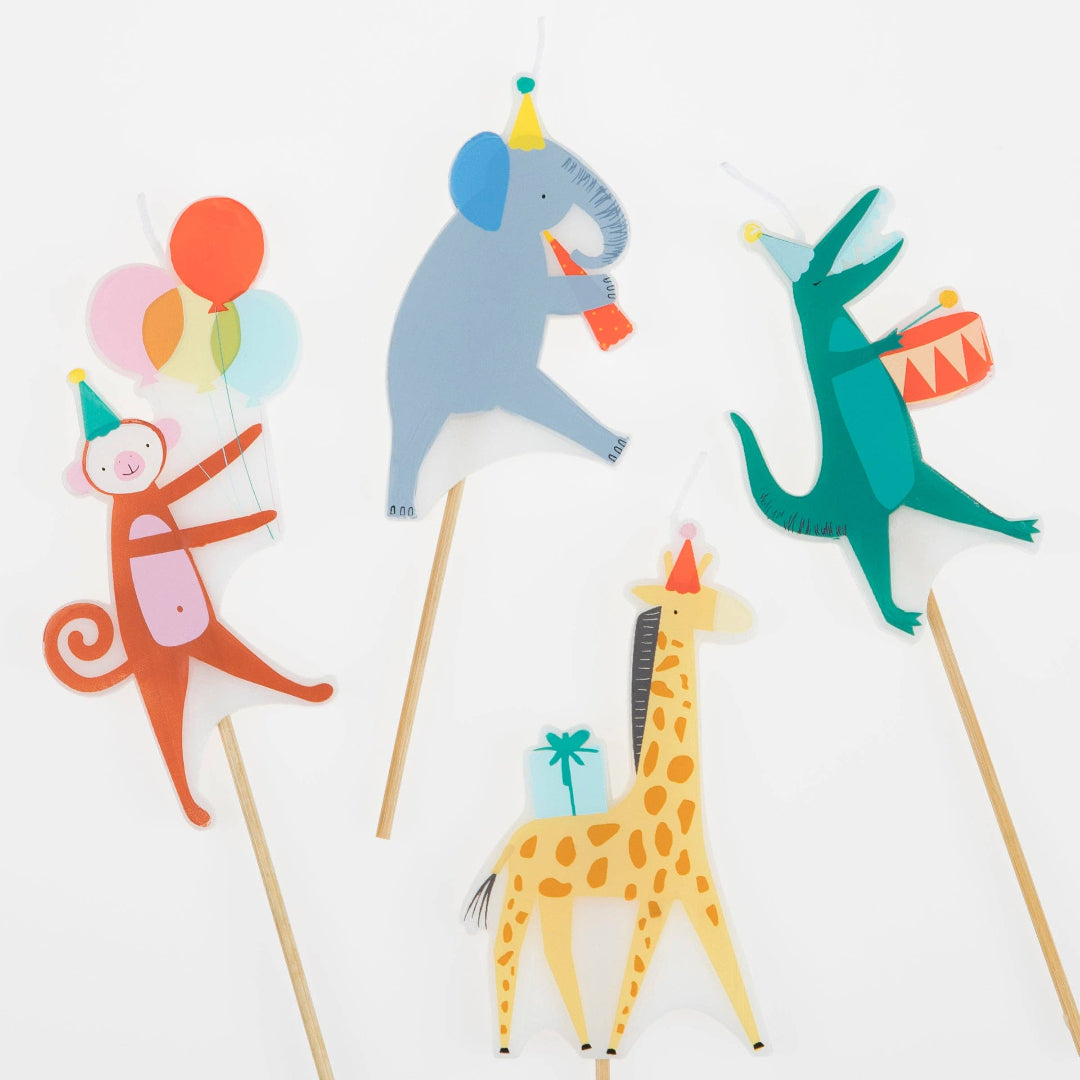 Colorful animal figurines on sticks with party hats and balloons against a white background