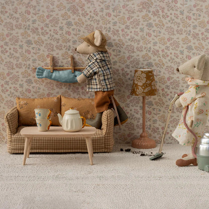 Two toy mice in a living room setting with furniture and decor.