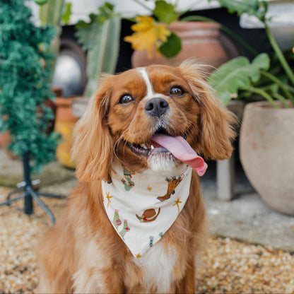 Brown dog wearing Cowboy Christmas Bamboo Pet Bandana while sitting in front of a decorated Christmas tree.