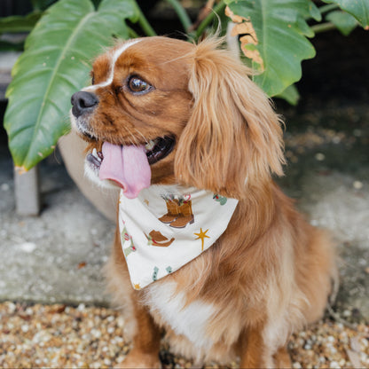Side view of brown dog modeling Cowboy Christmas Bamboo Pet Bandana with festive Western illustrations.