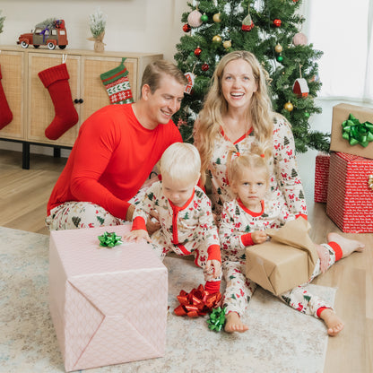 Family opens presents by the tree in matching Cozy Christmas bamboo pajamas with relaxed fit pants.