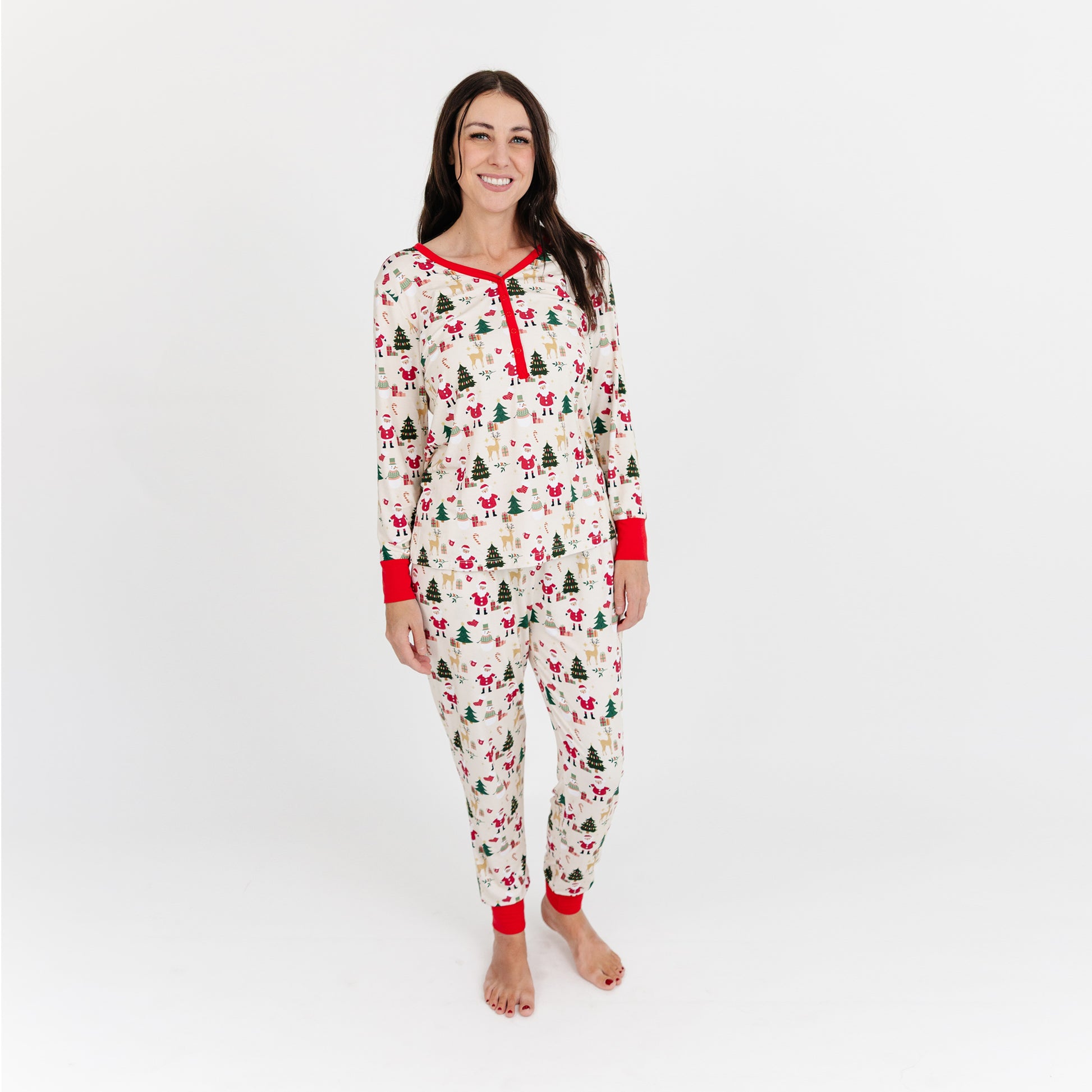 Woman models Cozy Christmas bamboo jogger pajama pants with red cuffs, showcasing buttery soft fabric and festive print.