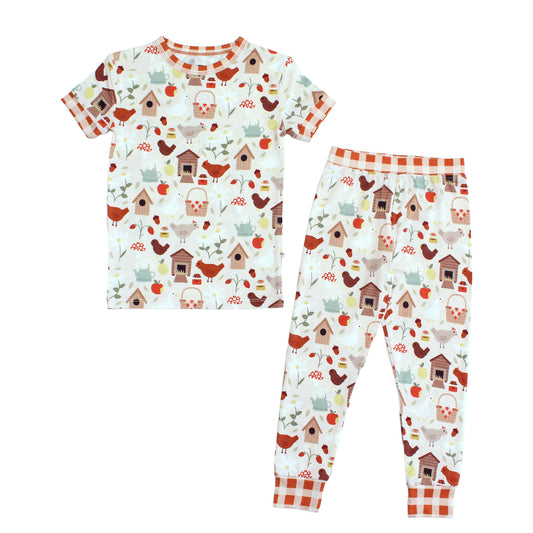 Emerson and Friends Cozy Cottage Bamboo Short Sleeve Kids Pajama Set, featuring a soft and breathable farmhouse-inspired print with chickens, birdhouses, apples, and gingham accents for a cozy bedtime look.