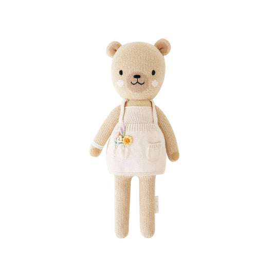 Knitted teddy bear with a white apron on a white background