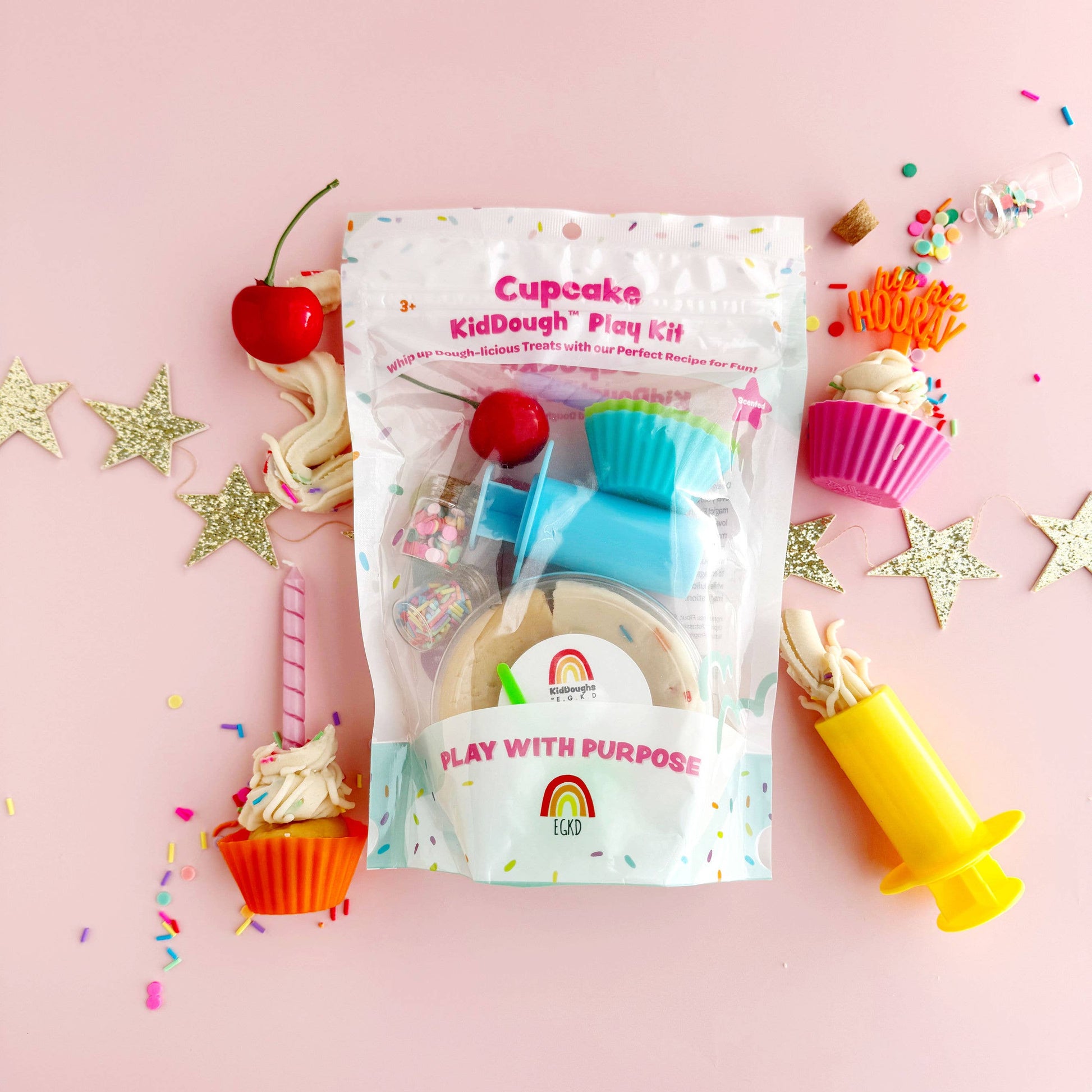 Cupcake-themed play dough kit with tools on a pink background