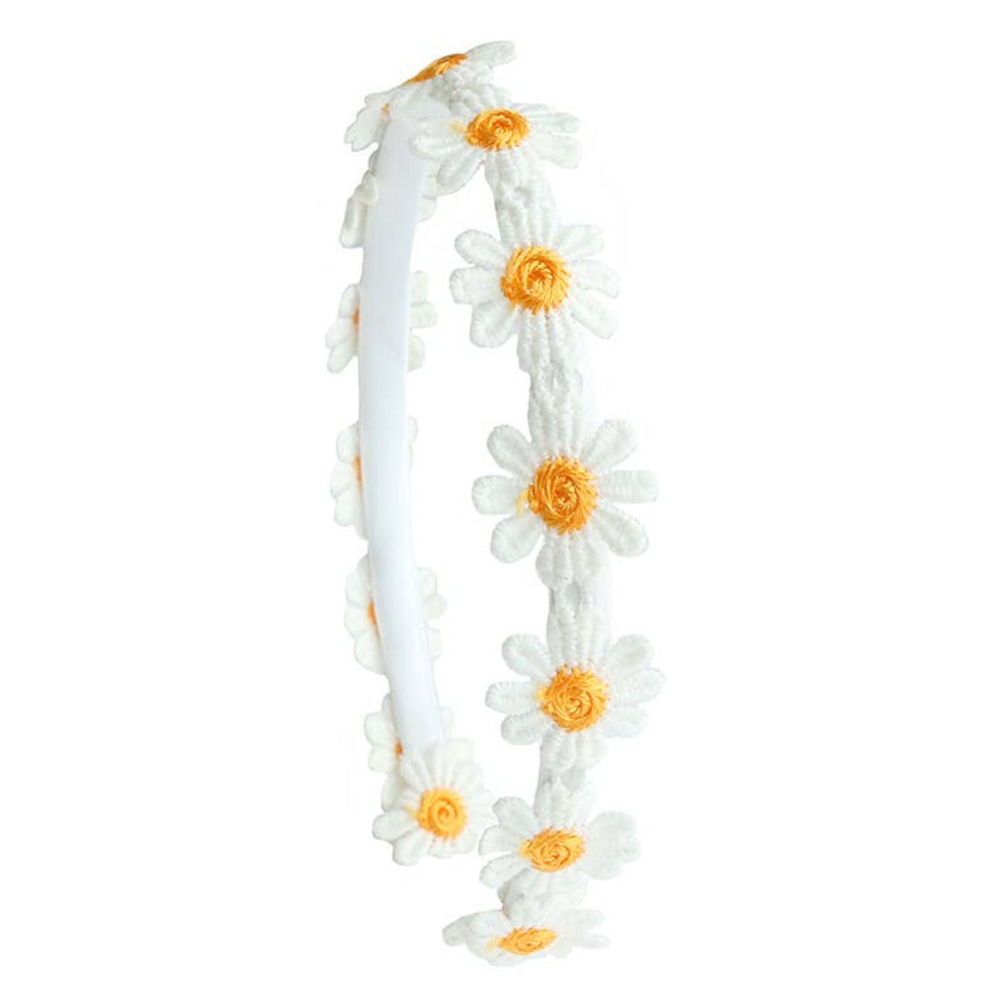 white headband with small white daisies lined along the headband