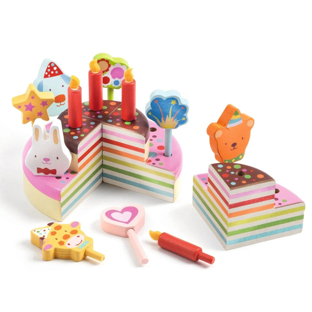 Colorful toy birthday cake set with candles and decorations on a white background