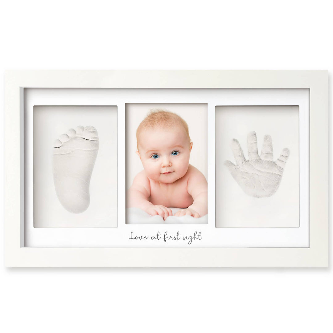 a picture frame that holds a baby footprint, handprint, and a picture