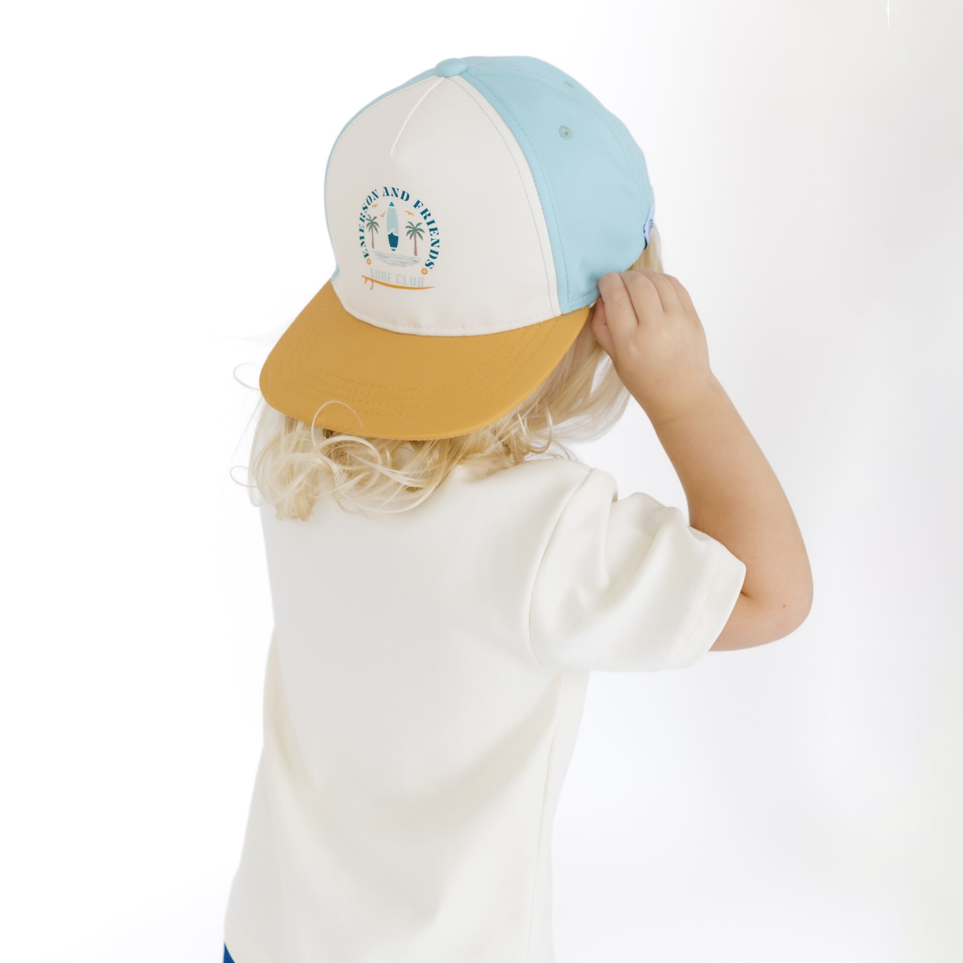 Child wearing a two-tone cap with a white background