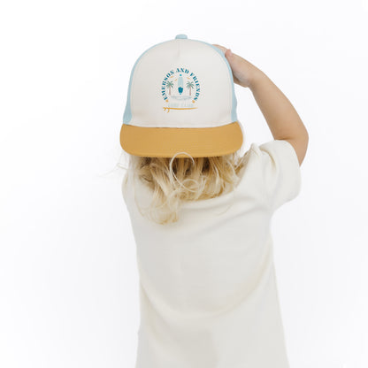 Child wearing a cap with a palm tree design on a white background