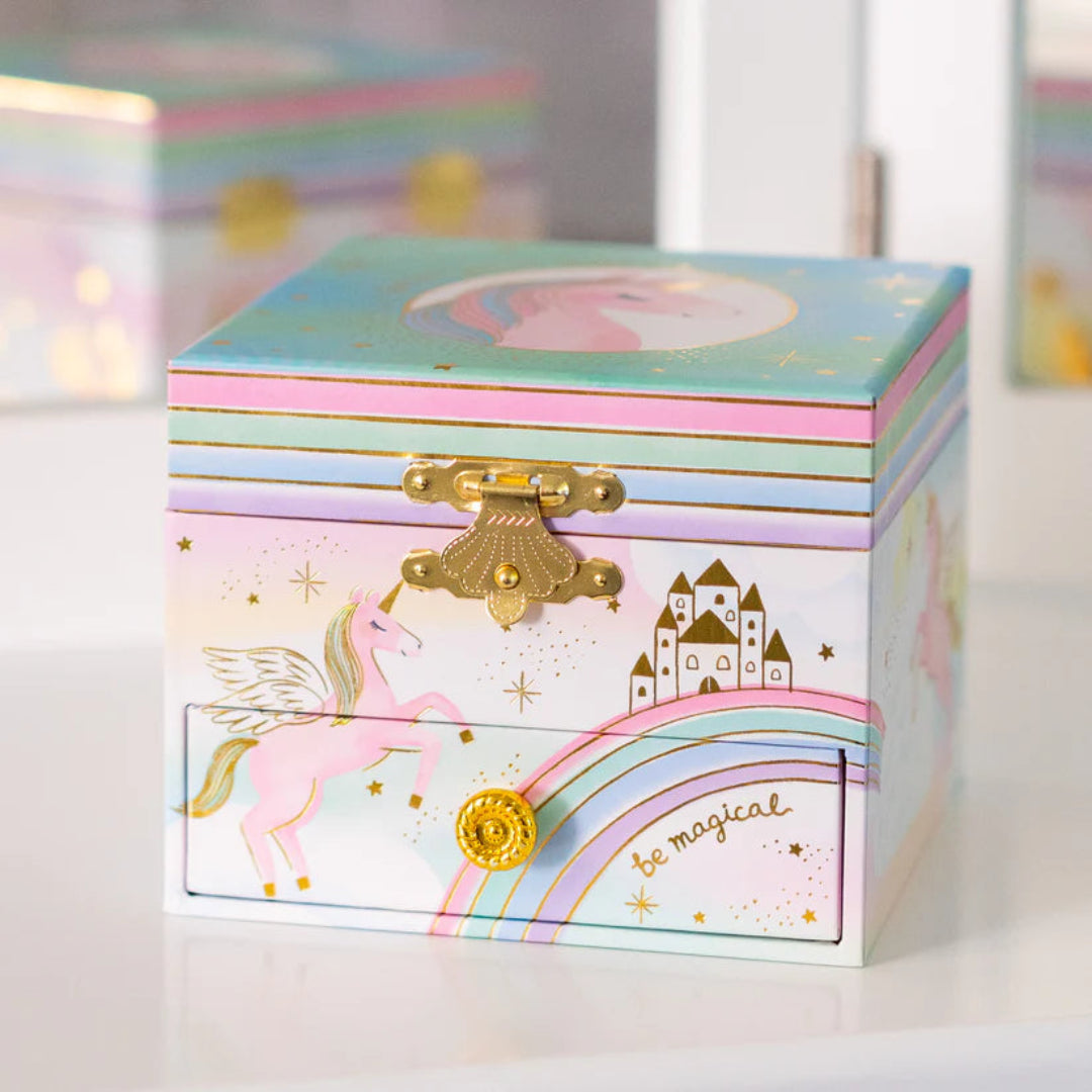 a colorful unicorn themed jewelry box that has gold embellishments and a drawer on the bottom
