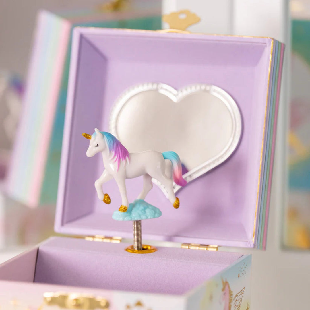 a jewelry box with a unicorn that spins inside and the box is purple inside with a heart shaped mirror on the back