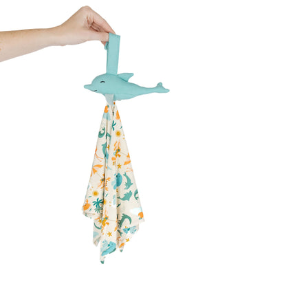 Dolphin-shaped holder with a swaddle blanket featuring dolphin prints on a white background