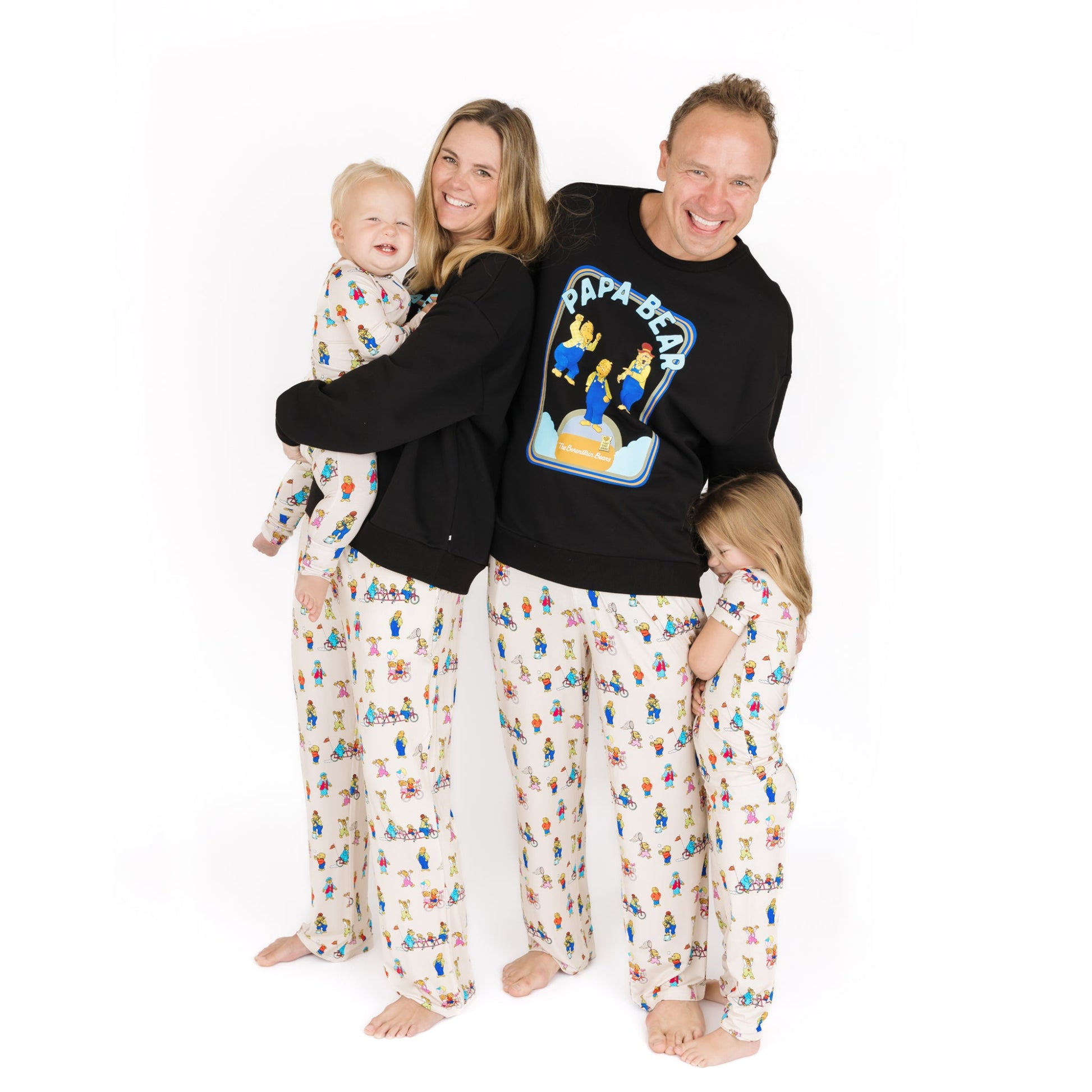 Family of four wearing matching pajamas with a white background