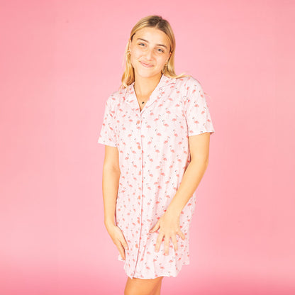 blonde girl in the "fancy flamingos" bamboo night gown. the "fancy flamingos" print is a pattern of multiple pink flamingoes scattered around the print. 