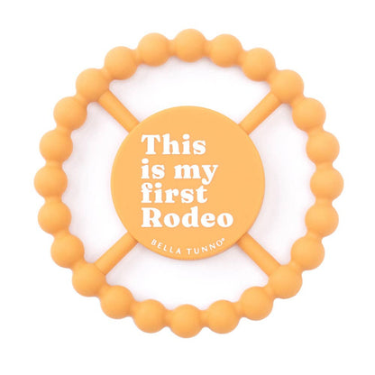 Round orange baby teether that says this is my first rodeo on the front