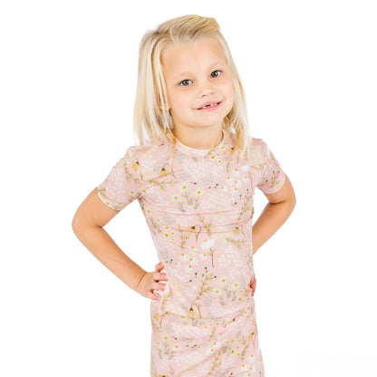 Young girl wearing a floral dress on a white background