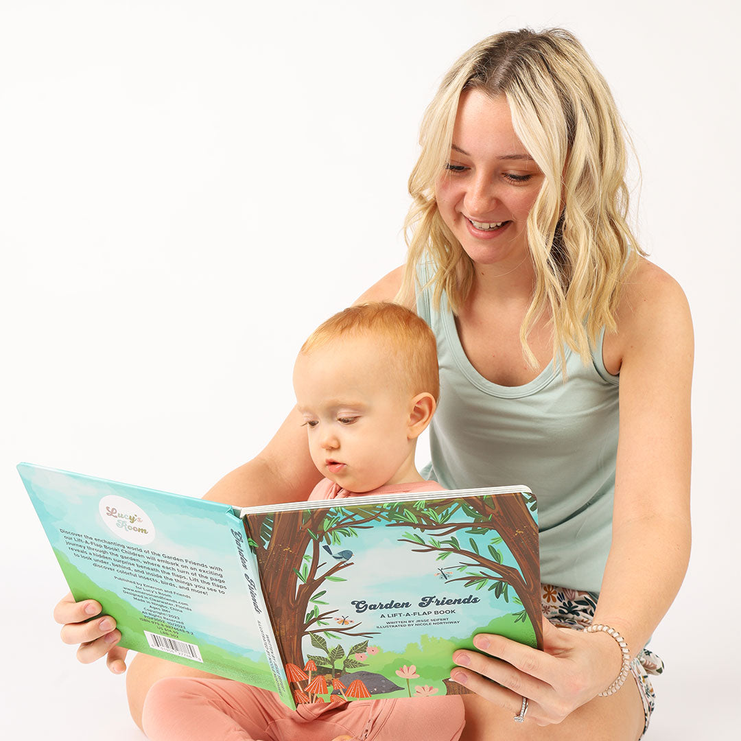 mom and baby sit and read the "Garden Friends" lift-a-flip board book. 