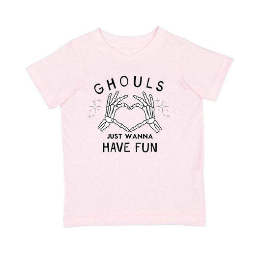 A light pink short-sleeve t-shirt with a black graphic print on the front. The graphic features the word 'GHOULS' above two skeleton hands forming a heart shape, with the text 'JUST WANNA HAVE FUN' below.