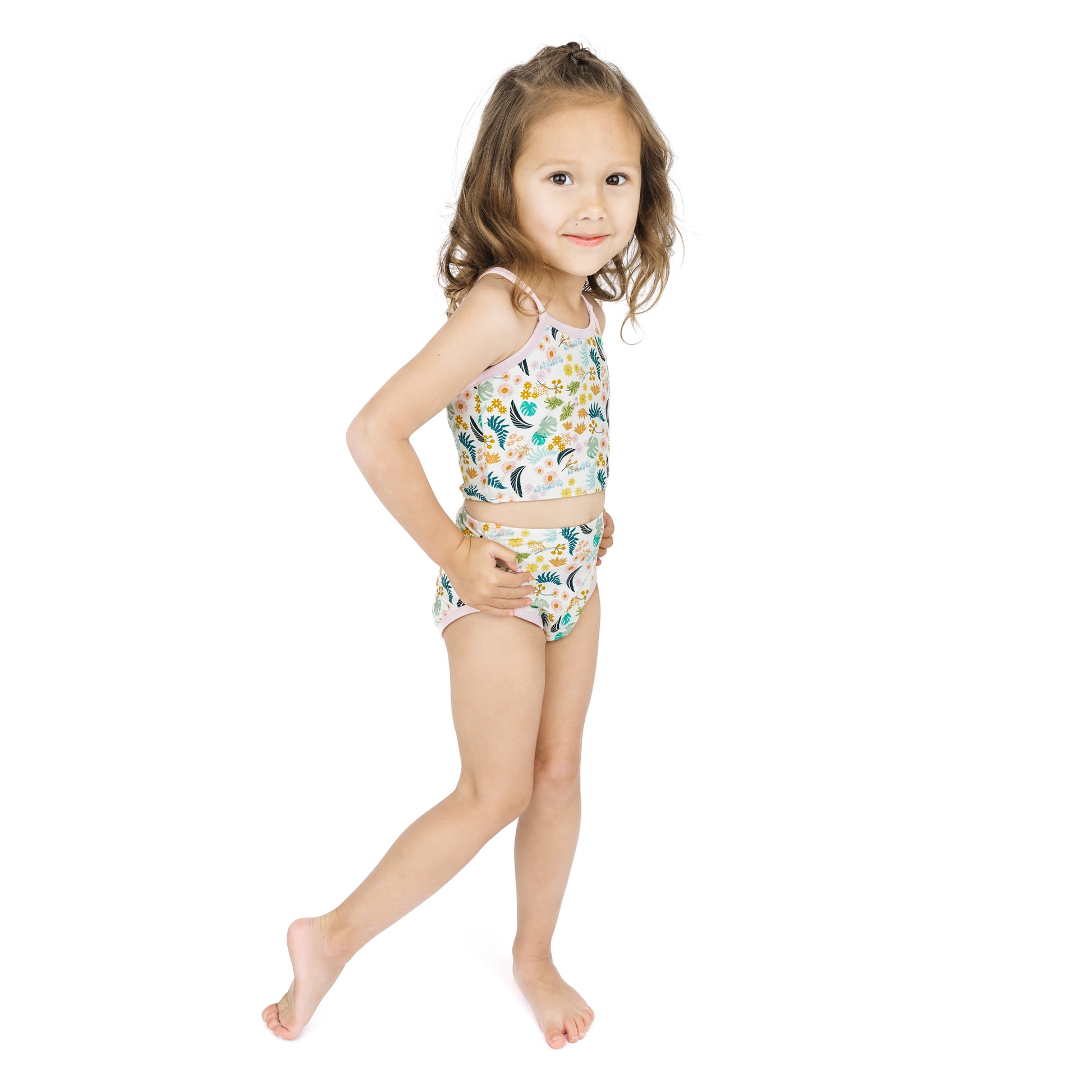 Full-length view of a young girl in the Tropical Blooms bikini, which offers UPF 50+ protection to block 98% of harmful UV rays.