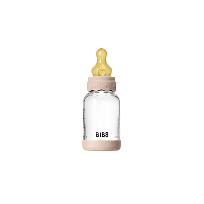 Clear baby bottle with pink cap and yellow nipple on a white background