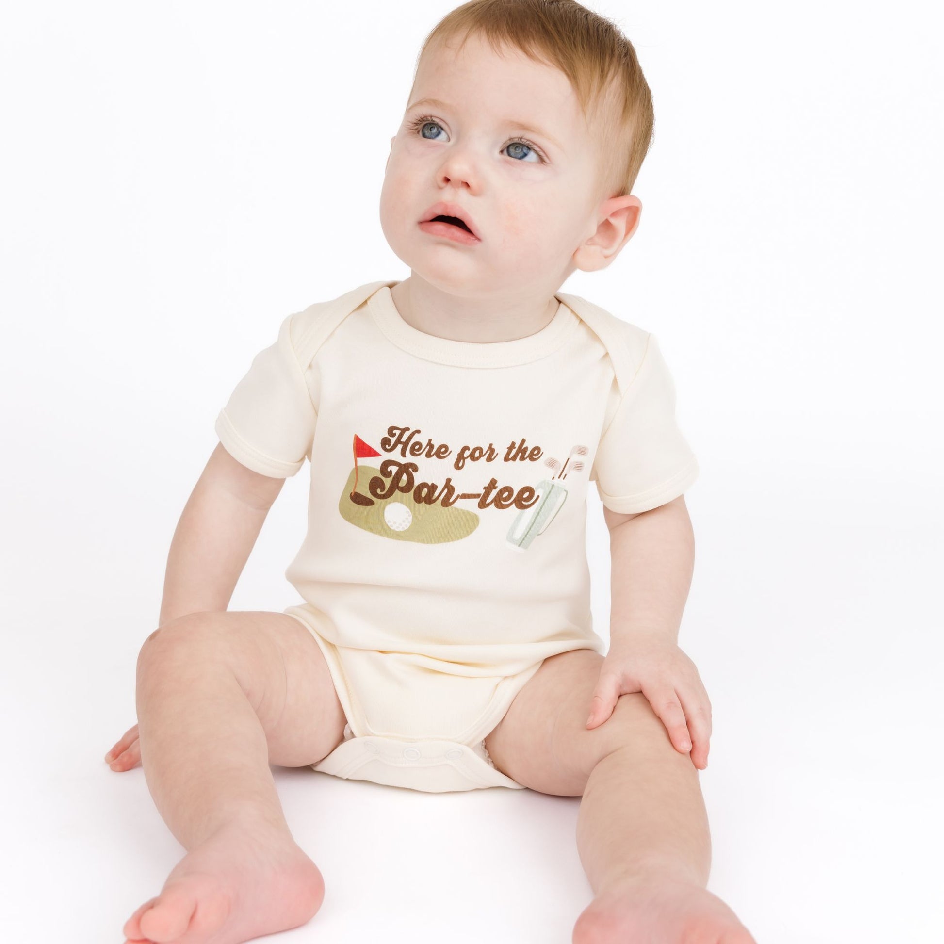Baby wearing a onesie with 'Here for the Par-tee' text on a white background