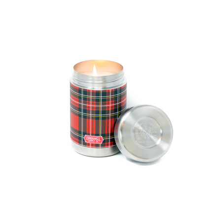 Candle in a tartan-patterned container with a lid on a white background
