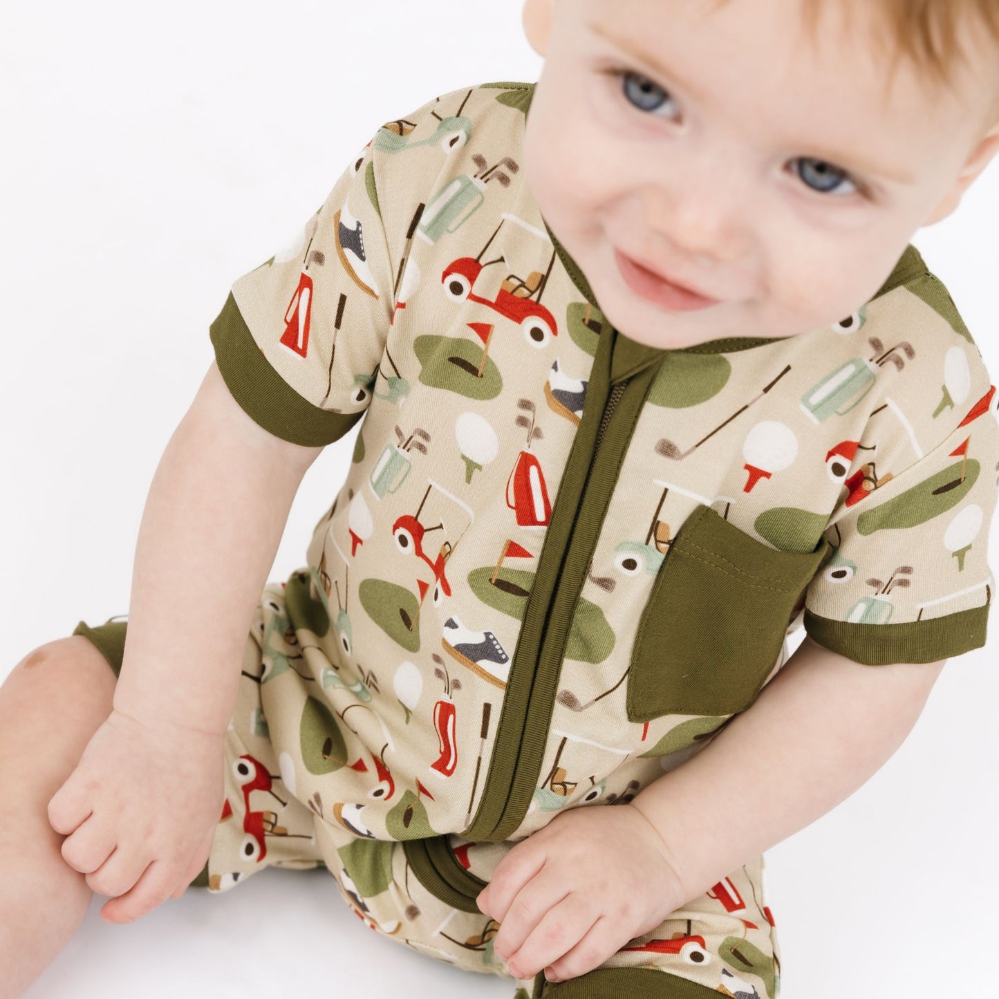 Baby wearing a patterned onesie with a neutral background