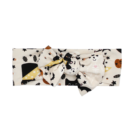 the "spooky cute beige" baby headband. the "spooky cute beige" print is a halloween themed pattern that contains cute versions go ghost, skeletons, black cats, candy treats, bats, and pumpkins. 