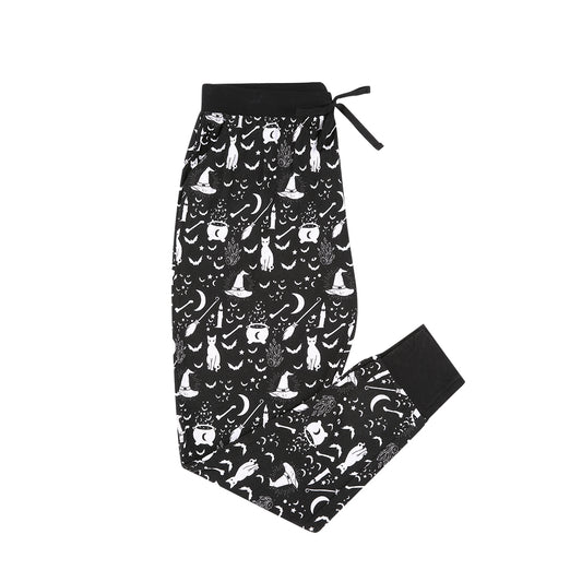 the "hocus pocus" women's jogger pants. the "hocus pocus" print is a blank and white print of spooky bats, witches hats and brooms, candles, stars, cars, crystals, and a brewing pot.