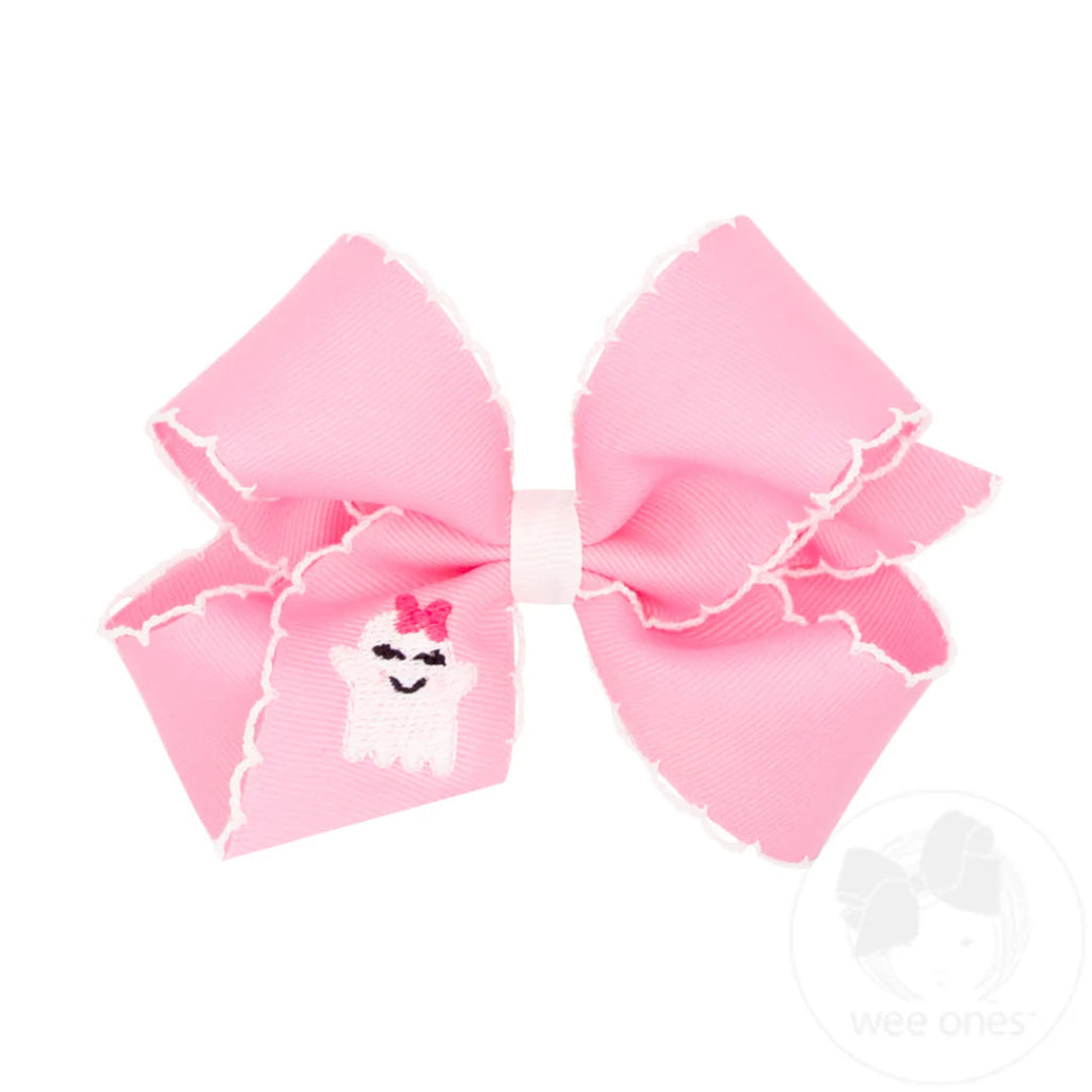 pink hair bow with white trim and an embroidered ghost on it