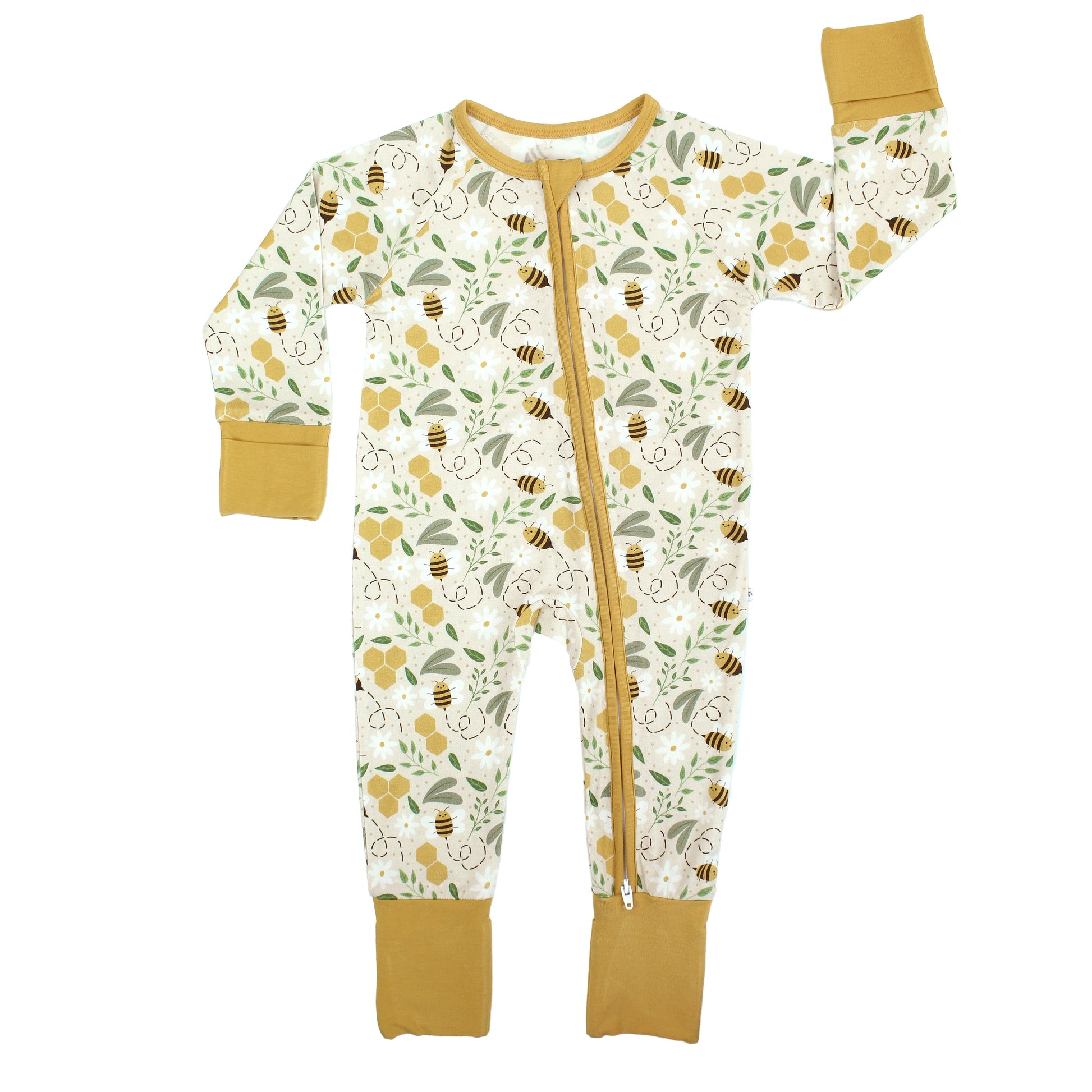 A baby in a breathable, hypoallergenic bamboo convertible pajama with a bee and honeycomb print, smiling at the camera.