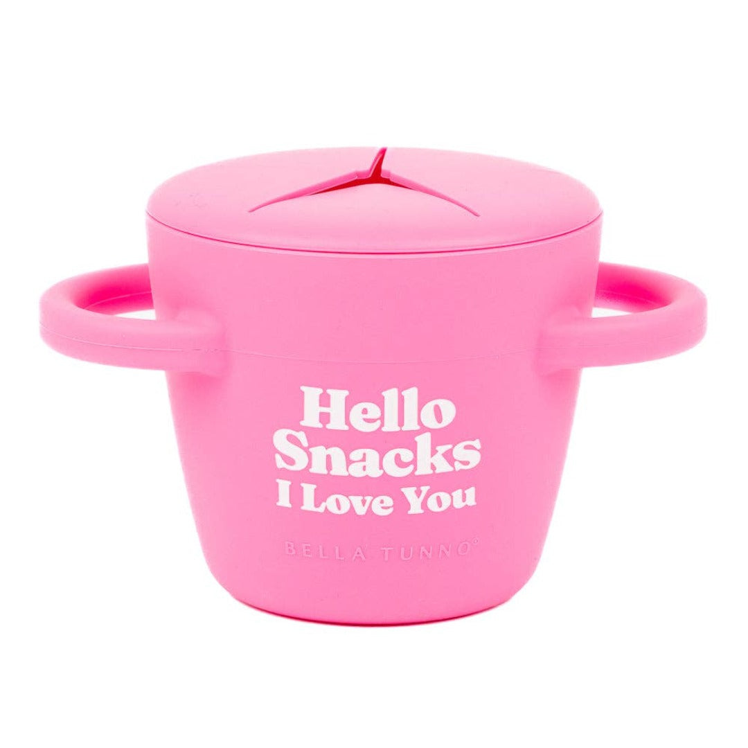 pink silicone kids snack cup that reads, hello snacks i love you,with handles on both sides and a slitted lid to prevent spilling 