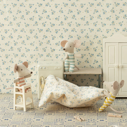 Children's room with floral wallpaper, toy mice, and a bed.