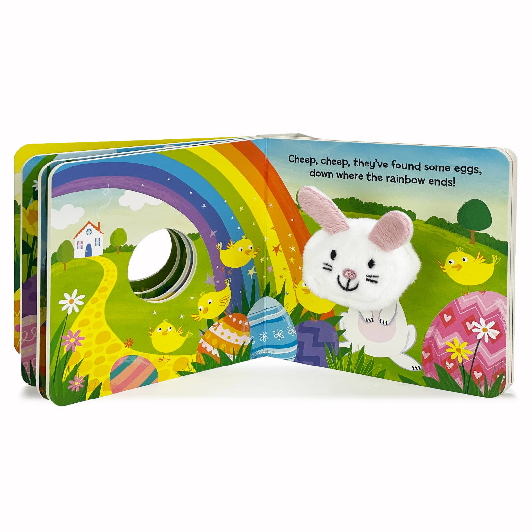 inside pages of an easter bunny themed board book with a bunny finger puppet in a field with a rainbow in the sky