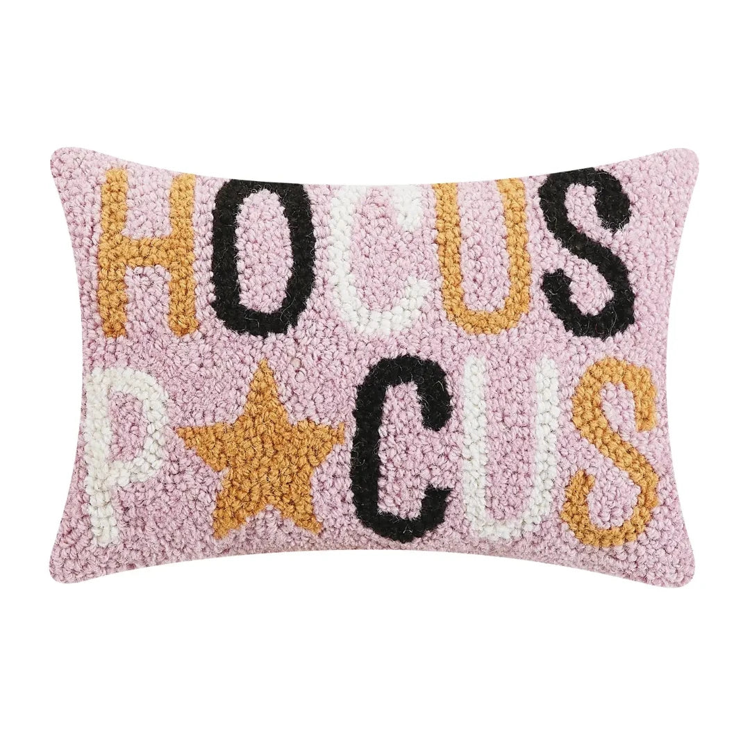 Pink decorative rectangle pillow with Hocus Pocus in orange, black and white letters