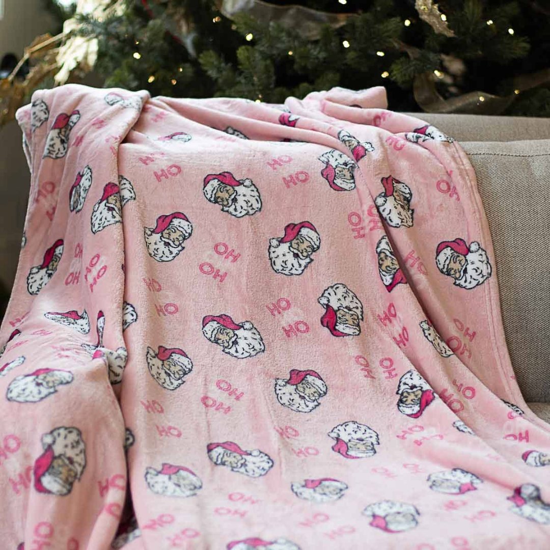 pink throw with Santa Claus faces on it and the words "hohoho"