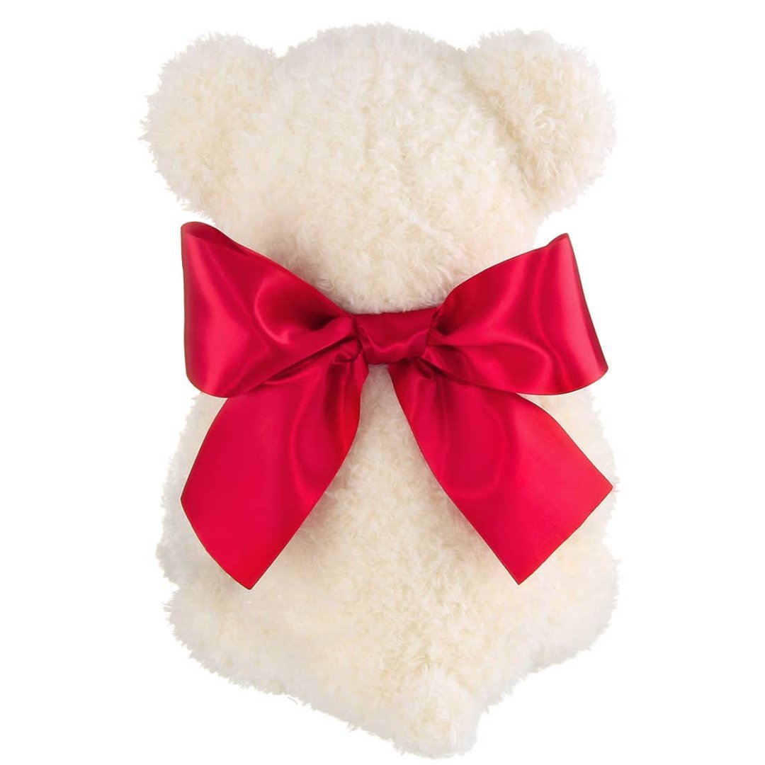 back side of a white bear with a red ribbon tied around its neck