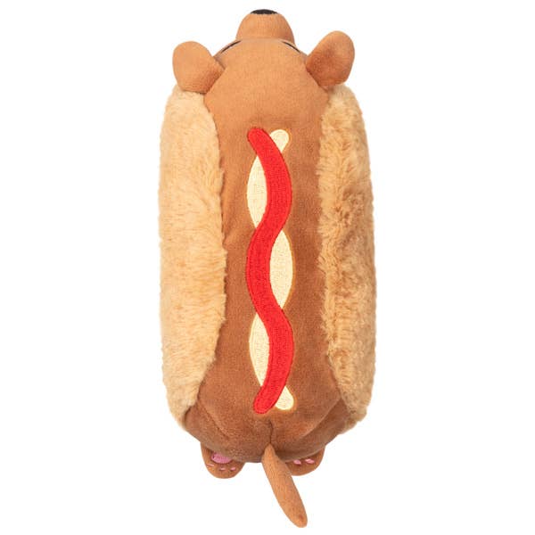Plush toy shaped like a hot dog with a brown bun and red filling on a white background