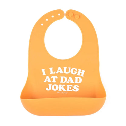 yellow baby bib that says i laugh at dad jokes on it