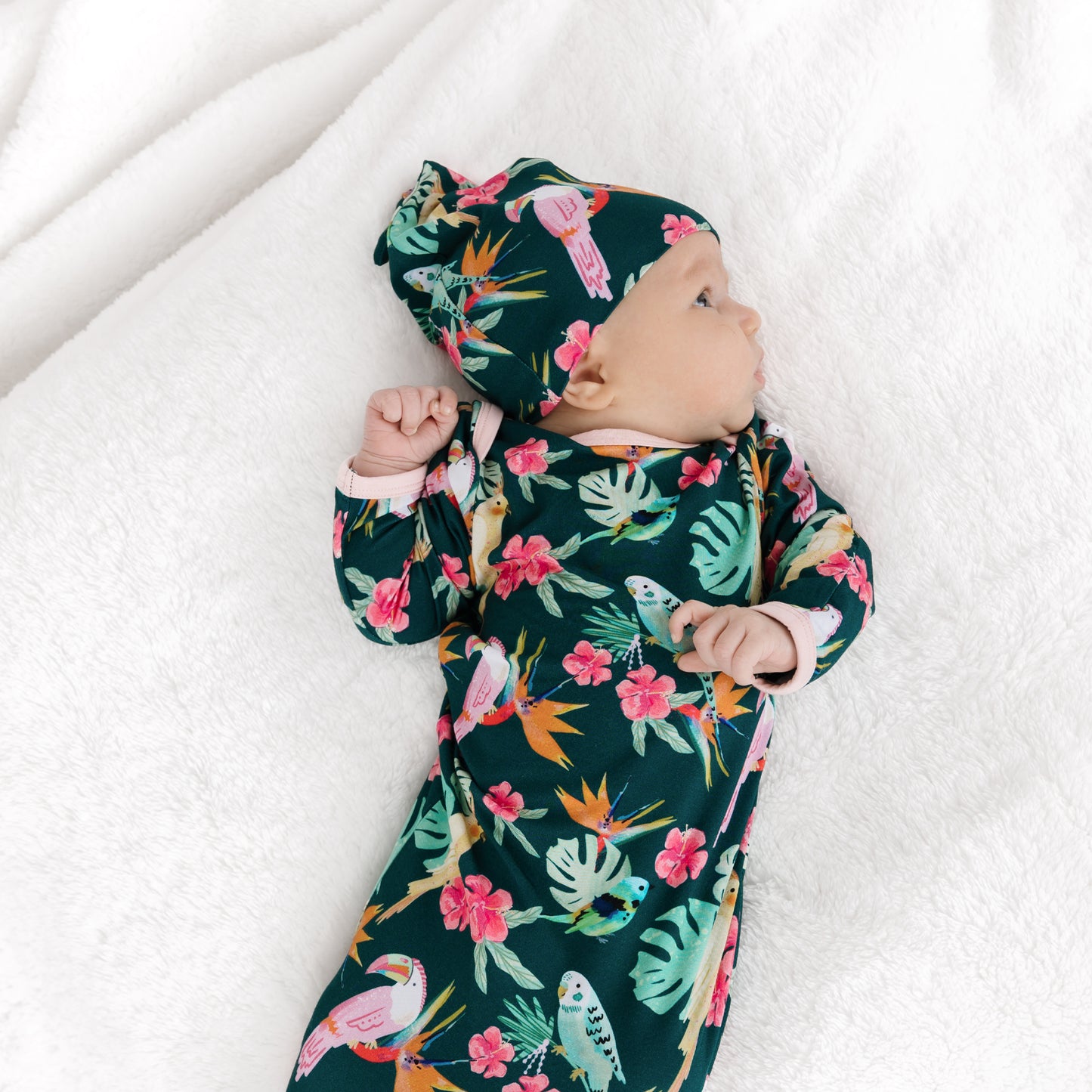 Back view of a sleeping newborn in the Isla Botánica print gown, highlighting the stretchy and soft bamboo fabric.