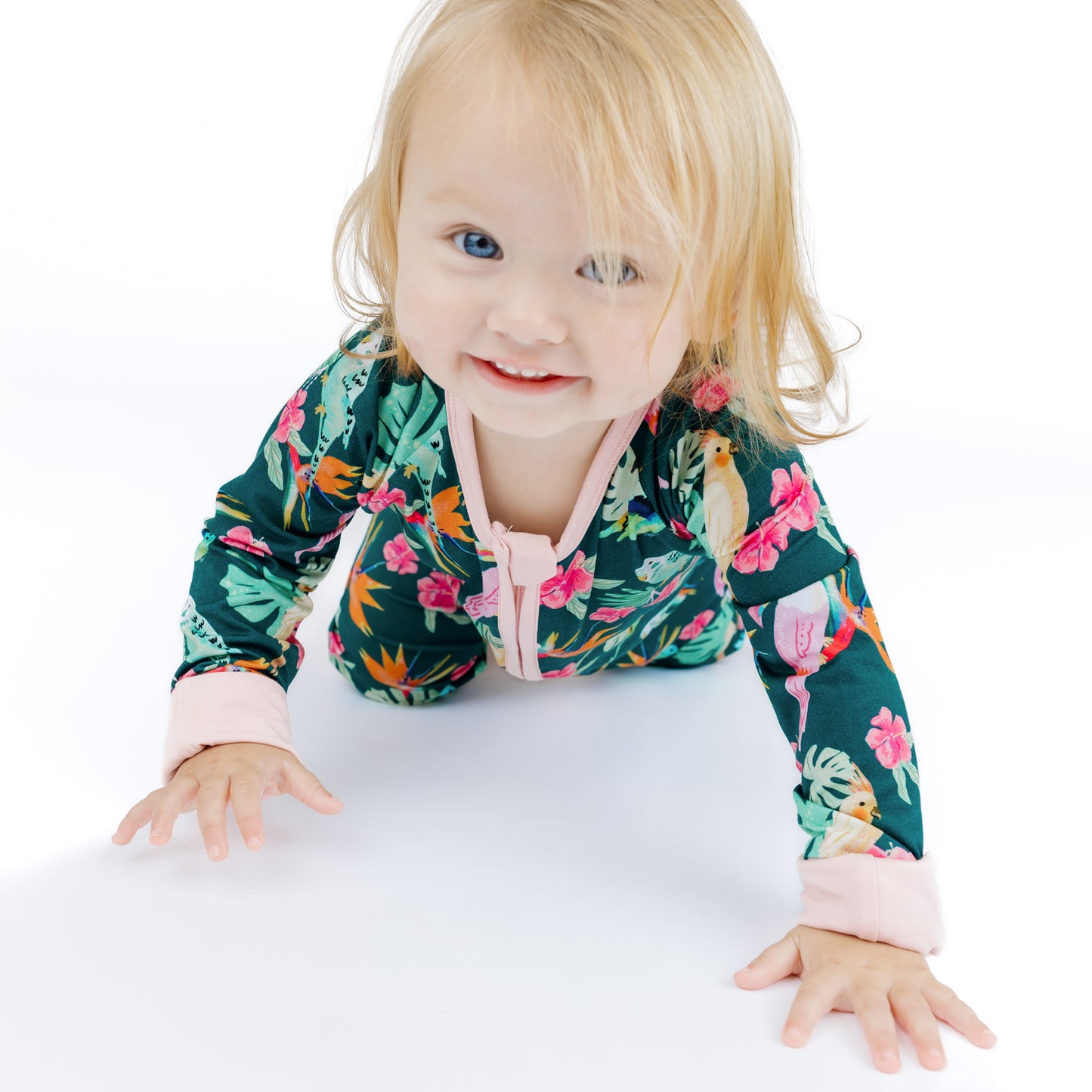 Close-up of a baby crawling in the Isla Botánica bamboo romper, highlighting the soft fabric and convertible footie design.