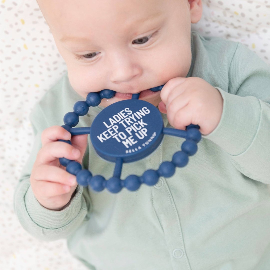 baby with teether in mouth